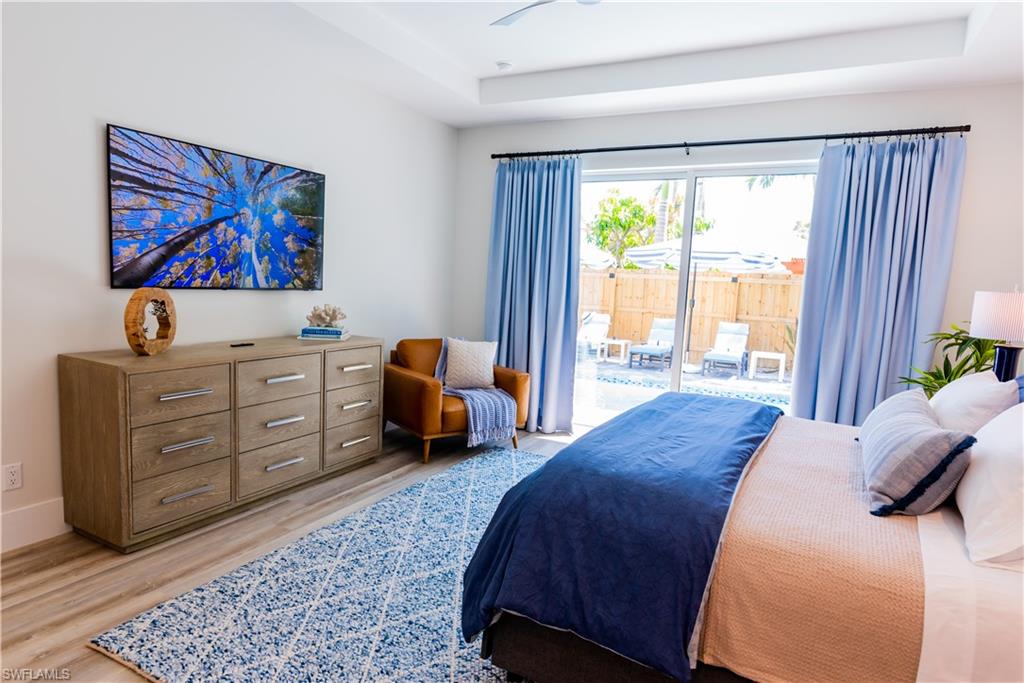 548 101st Avenue North Naples, FL 34108 - Photo 19 of 50 a spacious bedroom with a bed a couch and a window