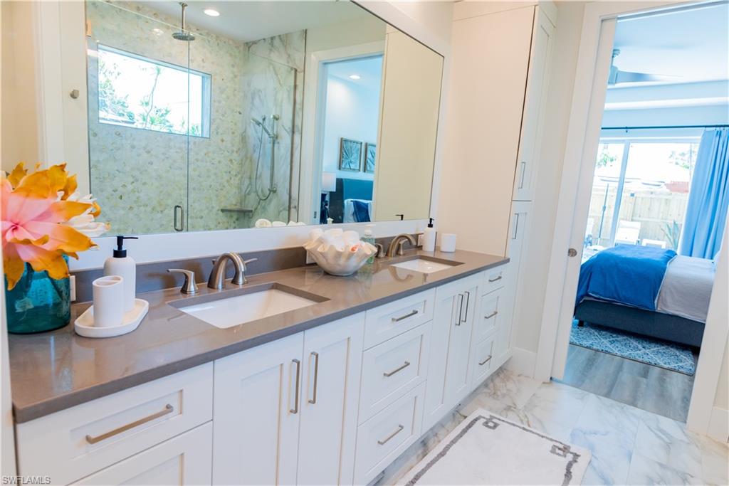548 101st Avenue North Naples, FL 34108 - Photo 22 of 50 a bathroom with double vanity sinks a mirror and a shower
