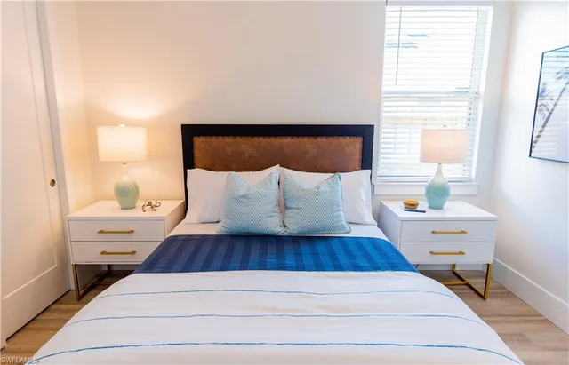 a view of a bedroom with wooden floor and window