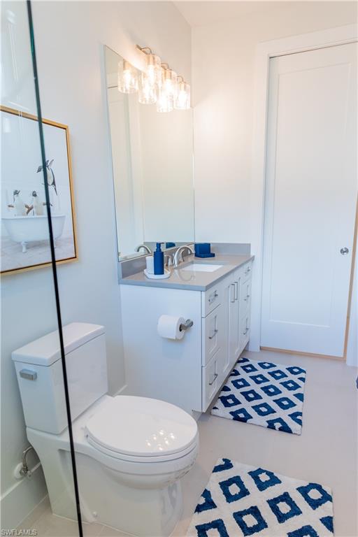 548 101st Avenue North Naples, FL 34108 - Photo 27 of 50 a bathroom with a sink a toilet a mirror and shower
