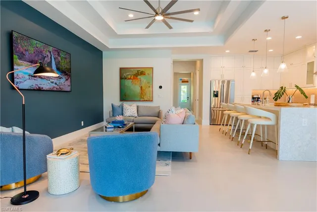 a living room with furniture kitchen view and a chandelier