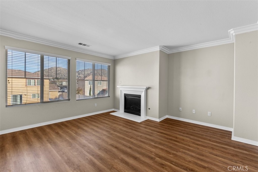 820 Volande Court Perris, CA 92571 - Photo 14 of 37 a view of empty room with wooden floor and fireplace