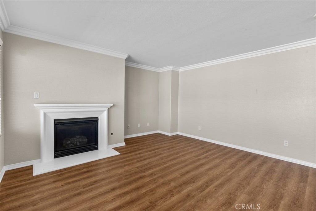 820 Volande Court Perris, CA 92571 - Photo 18 of 37 a view of an empty room with wooden floor fireplace and a window
