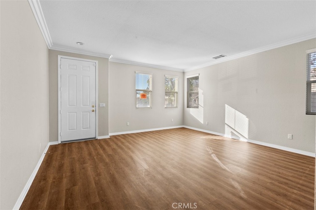 820 Volande Court Perris, CA 92571 - Photo 32 of 37 a view of an empty room with wooden floor and a window