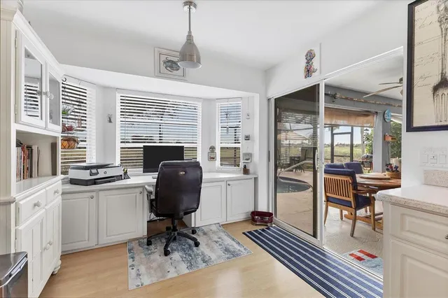 a view of a workspace with furniture and a window