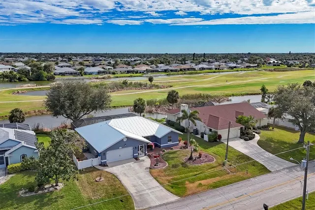 an aerial view of residential houses with outdoor space and trees