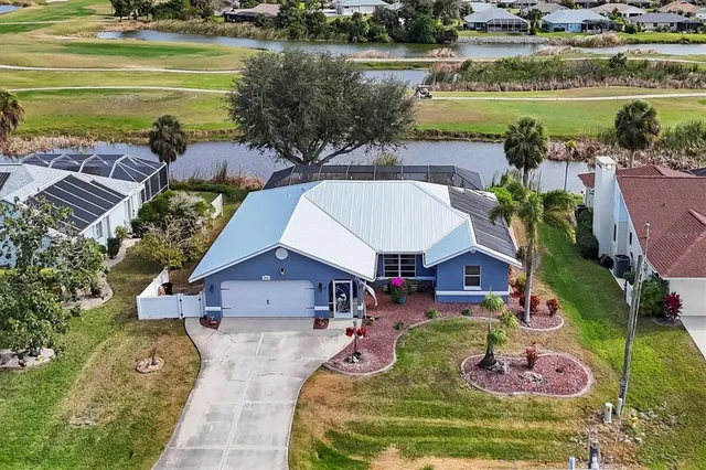 an aerial view of residential houses with outdoor space and trees