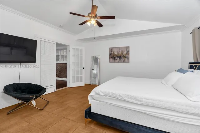 a bedroom with a bed a dresser and a flat screen tv