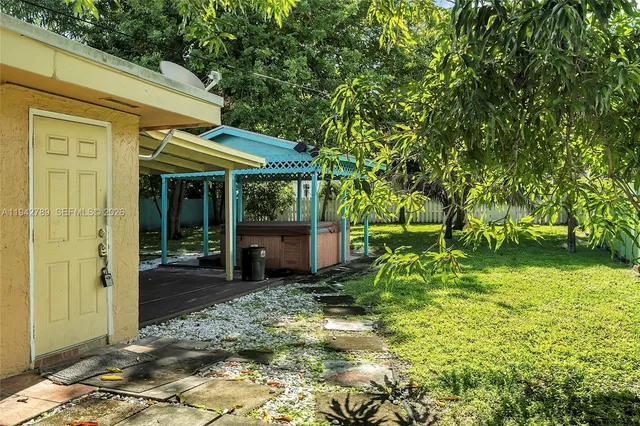 a view of a chair and table in backyard of the house