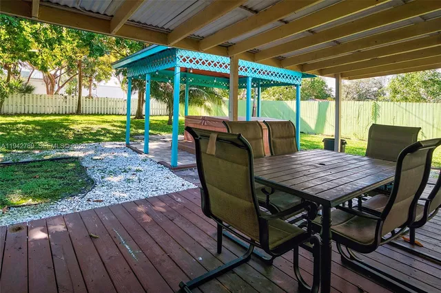 a view of a patio with a table chairs and a backyard