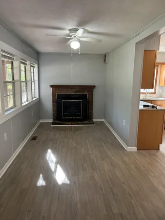 an empty room with windows and fireplace
