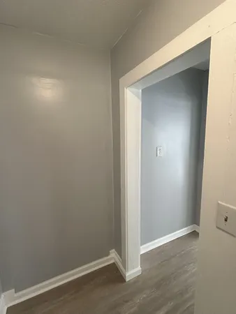 an empty room with wooden floor and closet