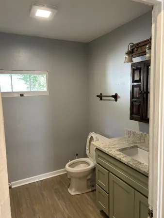 a bathroom with a granite countertop toilet and a sink