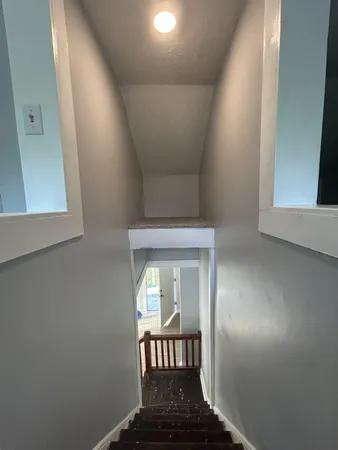 a view of a hallway with wooden floor and a hallway