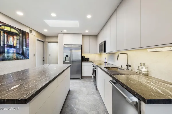 a large kitchen with stainless steel appliances granite countertop a sink and counter space