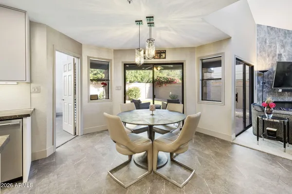 a dining room with furniture a chandelier and fireplace