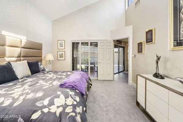 a spacious bedroom with a bed a couch and large window
