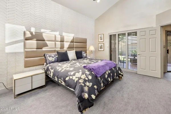 a spacious bedroom with a bed and glass window
