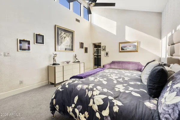 a bedroom with a bed and painting on the wall