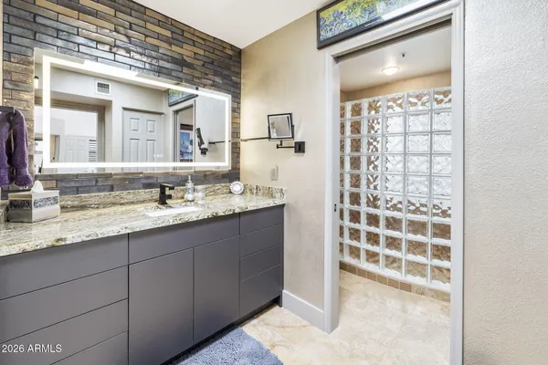 a bathroom with a granite countertop sink and a mirror