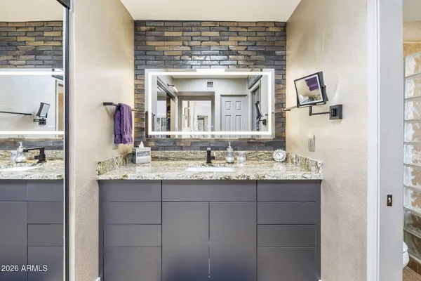 a bathroom with a granite countertop sink and a mirror