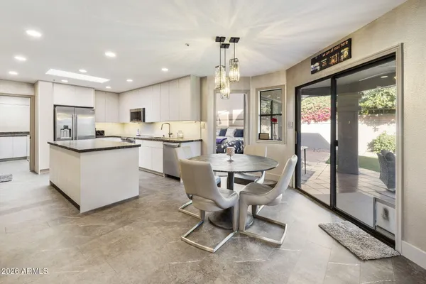 a dining room with kitchen island granite countertop furniture and a large window