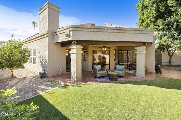 a view of a house with backyard and sitting area
