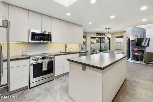 a kitchen with stainless steel appliances granite countertop a stove a sink and a microwave