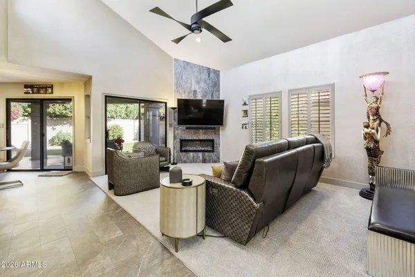 a living room with furniture a flat screen tv and a fireplace