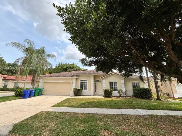 a front view of a house with a yard and potted plants