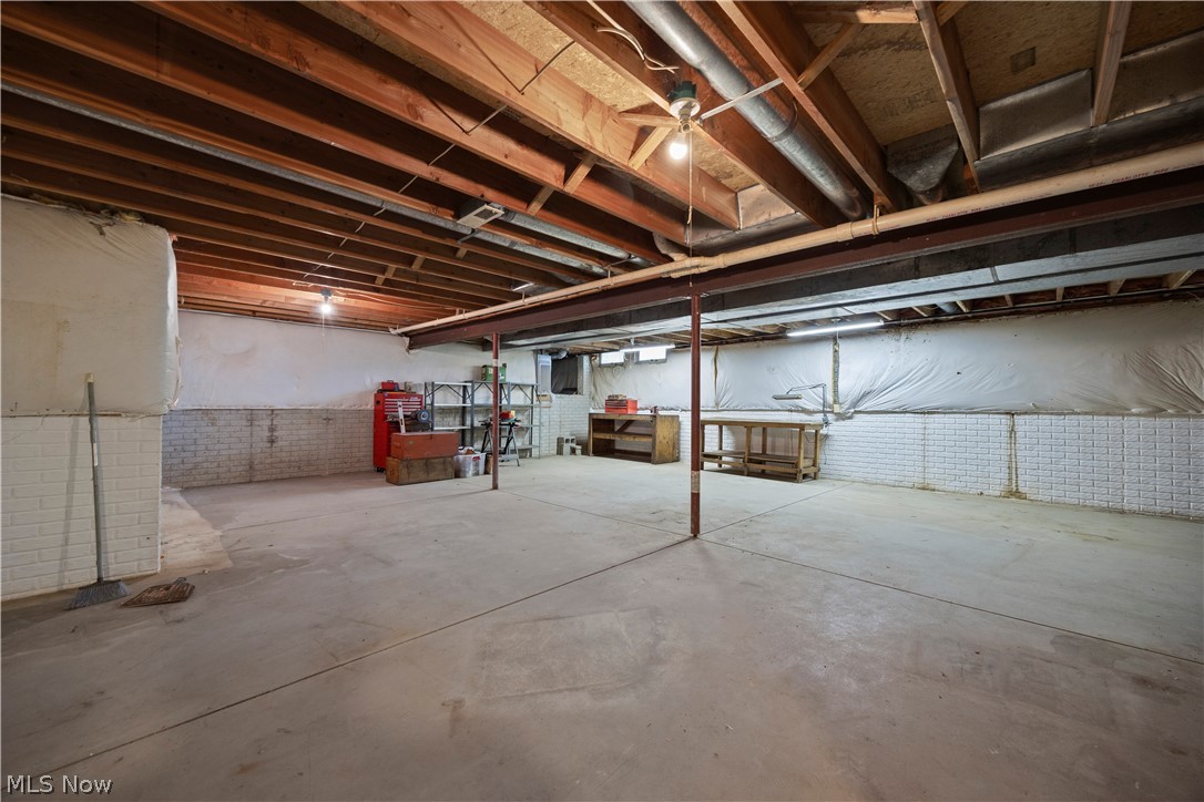 722 Jaycox Road Avon Lake, OH 44012 - Photo 39 of 48 Spacious unfinished basement featuring concrete flooring, exposed wood joists, and brick-patterned lower walls