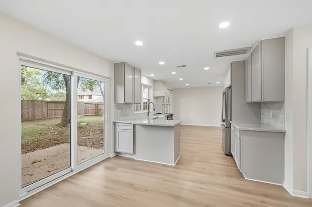a large kitchen with stainless steel appliances granite countertop a stove and a sink