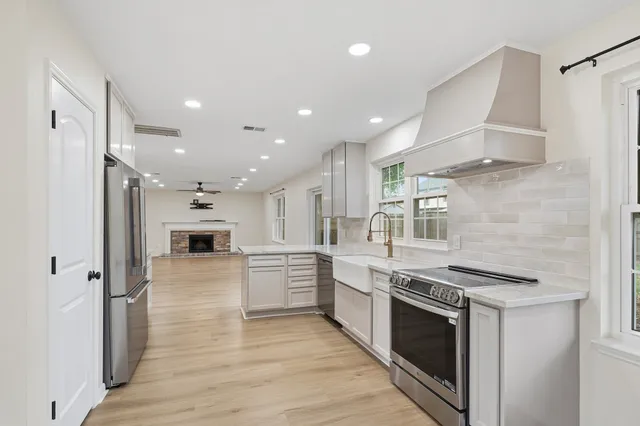 a kitchen with stainless steel appliances kitchen island granite countertop a stove and a refrigerator