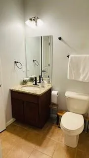 a bathroom with a sink vanity mirror and toilet