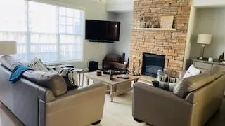 a living room with furniture a flat screen tv and a fireplace