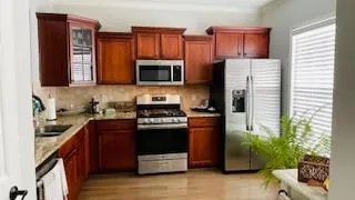 a kitchen with stainless steel appliances granite countertop a refrigerator stove and microwave