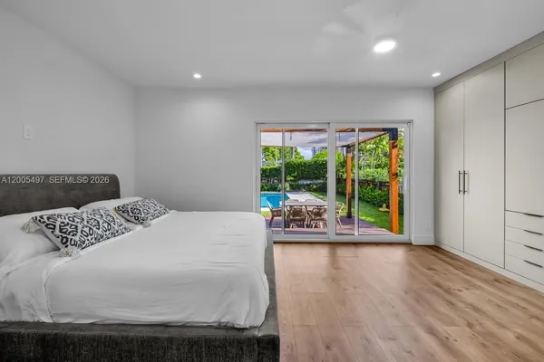 a bedroom with a bed and a wooden floor