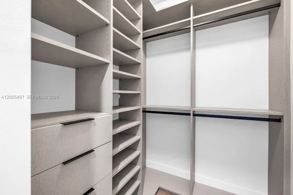 a view of walk in closet with empty racks