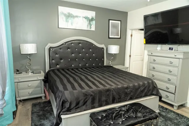 a bedroom with a bed and a flat screen tv