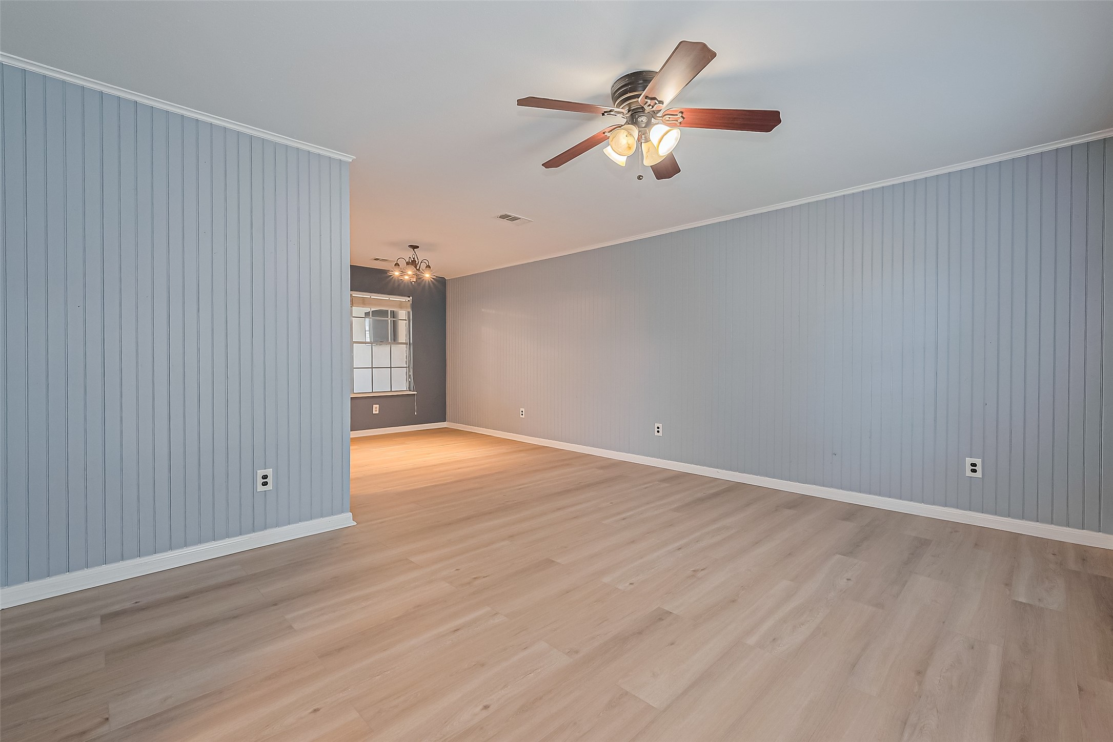 1010 Cheyenne Meadows Drive Katy, TX 77450 - Photo 12 of 41 an empty room with wooden floor chandelier fan and windows