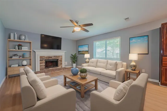 a living room with furniture a fireplace and a flat screen tv