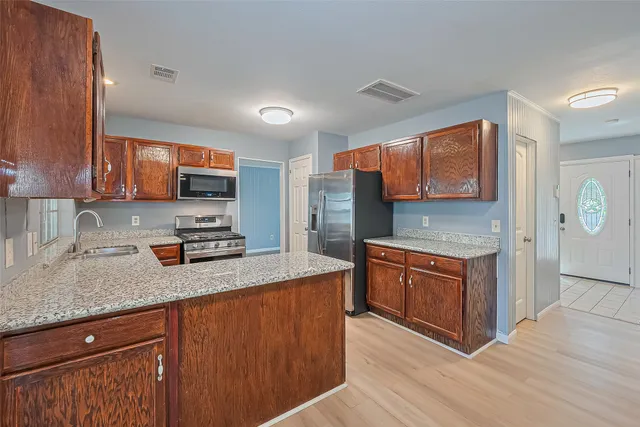 a kitchen with stainless steel appliances granite countertop a stove a sink and a granite counter tops