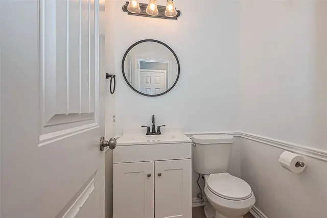 a bathroom with a toilet a sink and a mirror