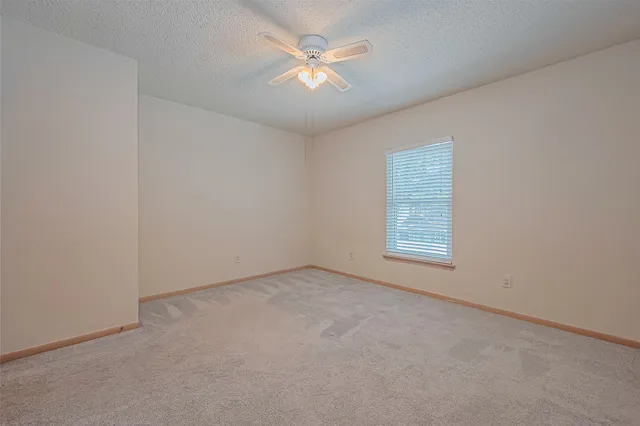 an empty room with closet and a ceiling fan