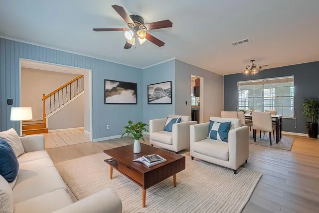a living room with furniture and a wooden floor