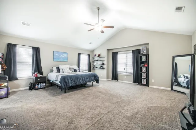 a bedroom with a large bed and a chandelier
