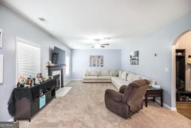 a living room with furniture a fireplace and a flat screen tv