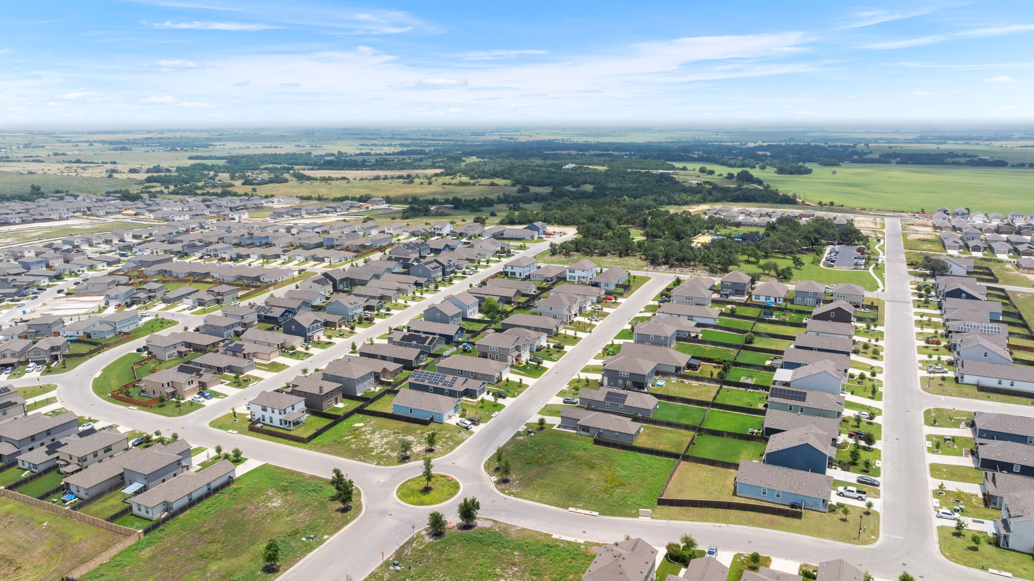 313 Mclintock Road Jarrell, TX 76537 - Photo 34 of 40 An aerial panorama reveals a flourishing suburban community with expansive green fields in the distance.