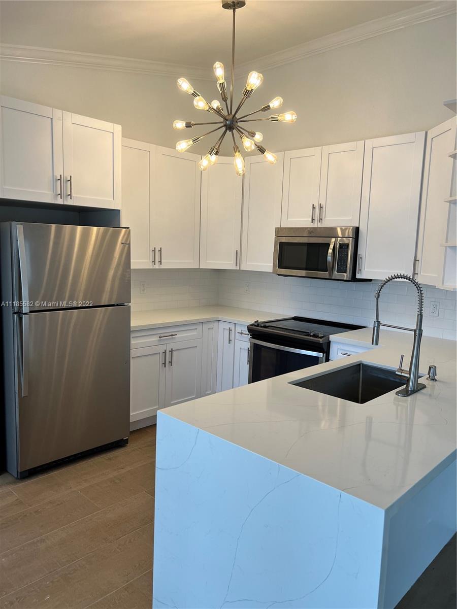 11156 Goss Lane Boca Raton, FL 33428 - Photo 5 of 20 a kitchen with stainless steel appliances a stove a sink and a refrigerator