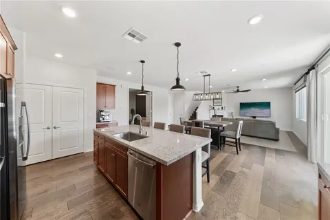 a large kitchen with kitchen island a sink a stove a dining table and chairs